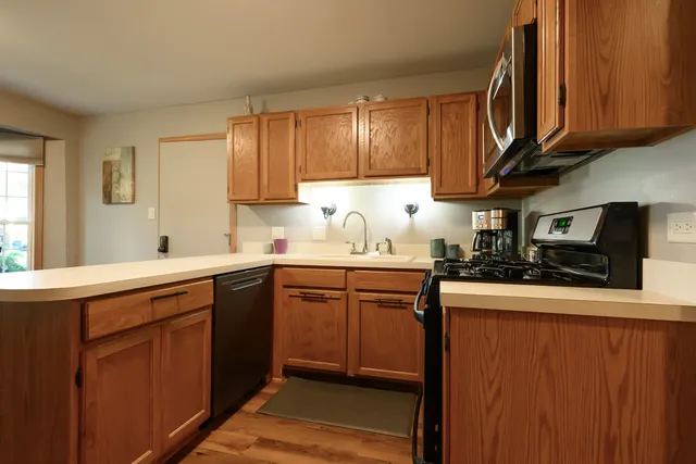 a kitchen with stainless steel appliances granite countertop wooden cabinets a sink and dishwasher
