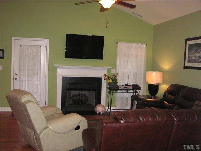 7260 Turner Fish Road Willow Spring, NC 27592 - Photo 2 of 14 a living room with furniture a flat screen tv and a fireplace