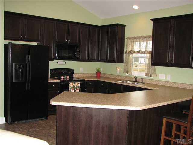7260 Turner Fish Road Willow Spring, NC 27592 - Photo 3 of 14 a kitchen with a sink a stove and refrigerator