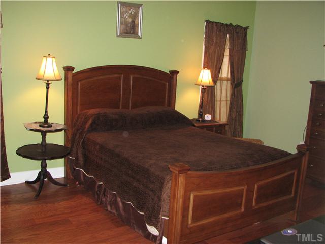 7260 Turner Fish Road Willow Spring, NC 27592 - Photo 6 of 14 a bedroom with a bed and a chandelier