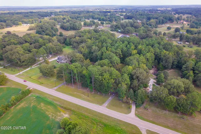 an aerial view of residential houses with outdoor space and trees