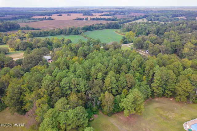 an aerial view of a houses with a lush green hillside
