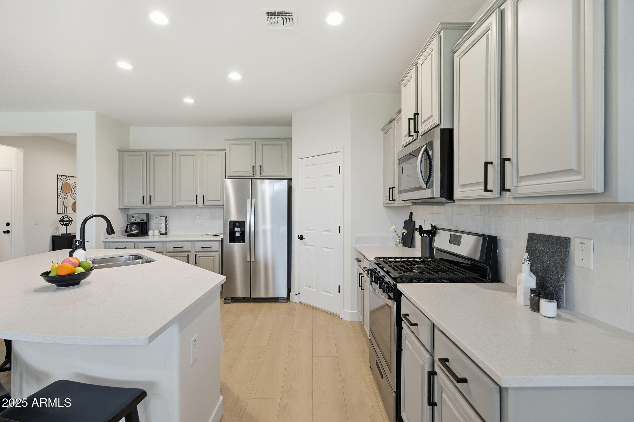 8159 West Cinder Brook Way Florence, AZ 85132 - Photo 12 of 32 a kitchen with stainless steel appliances a stove a sink a refrigerator and cabinets
