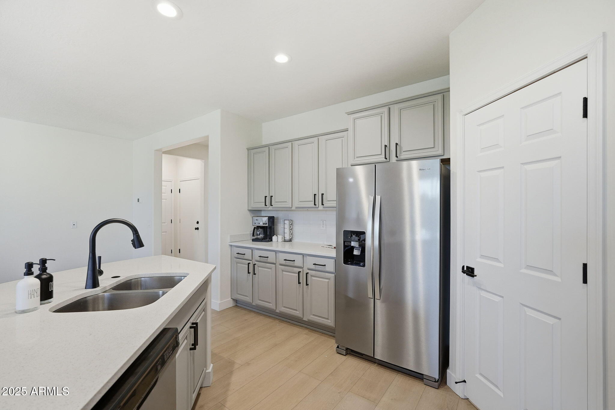 8159 West Cinder Brook Way Florence, AZ 85132 - Photo 17 of 32 a kitchen with white cabinets sink and refrigerator