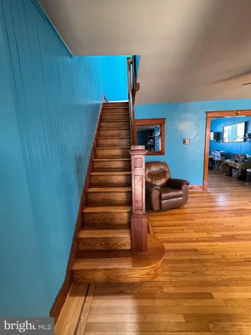 a view of entryway bedroom and hall with wooden floor