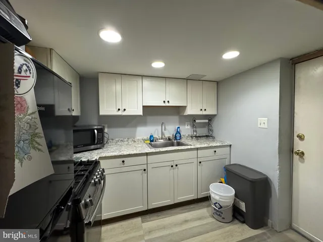 a kitchen with stainless steel appliances granite countertop a sink a stove and a refrigerator