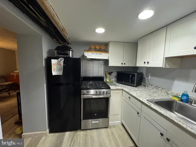 a kitchen with granite countertop a sink a stove and cabinets