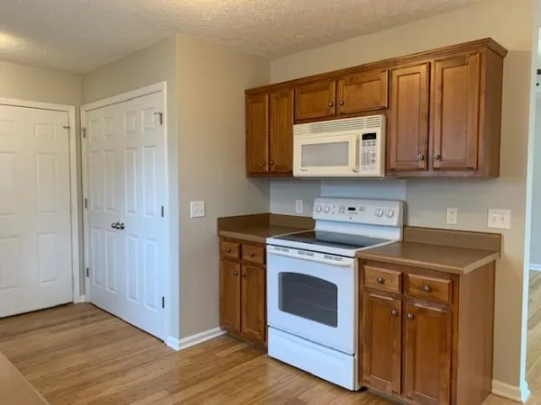 a kitchen with cabinets appliances and a wooden floor