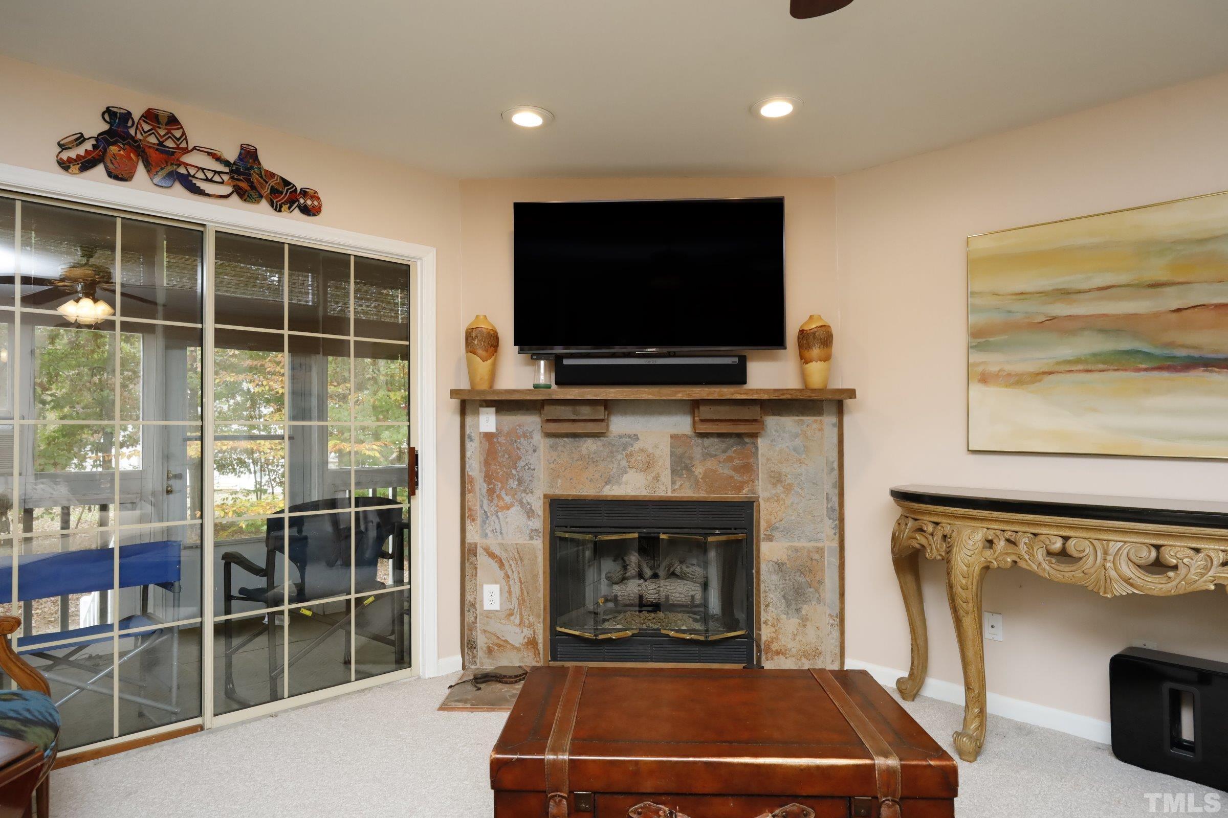 8331 Hempshire Place, Unit 102 Raleigh, NC 27613 - Photo 11 of 40 a living room with a flat screen tv and a fireplace