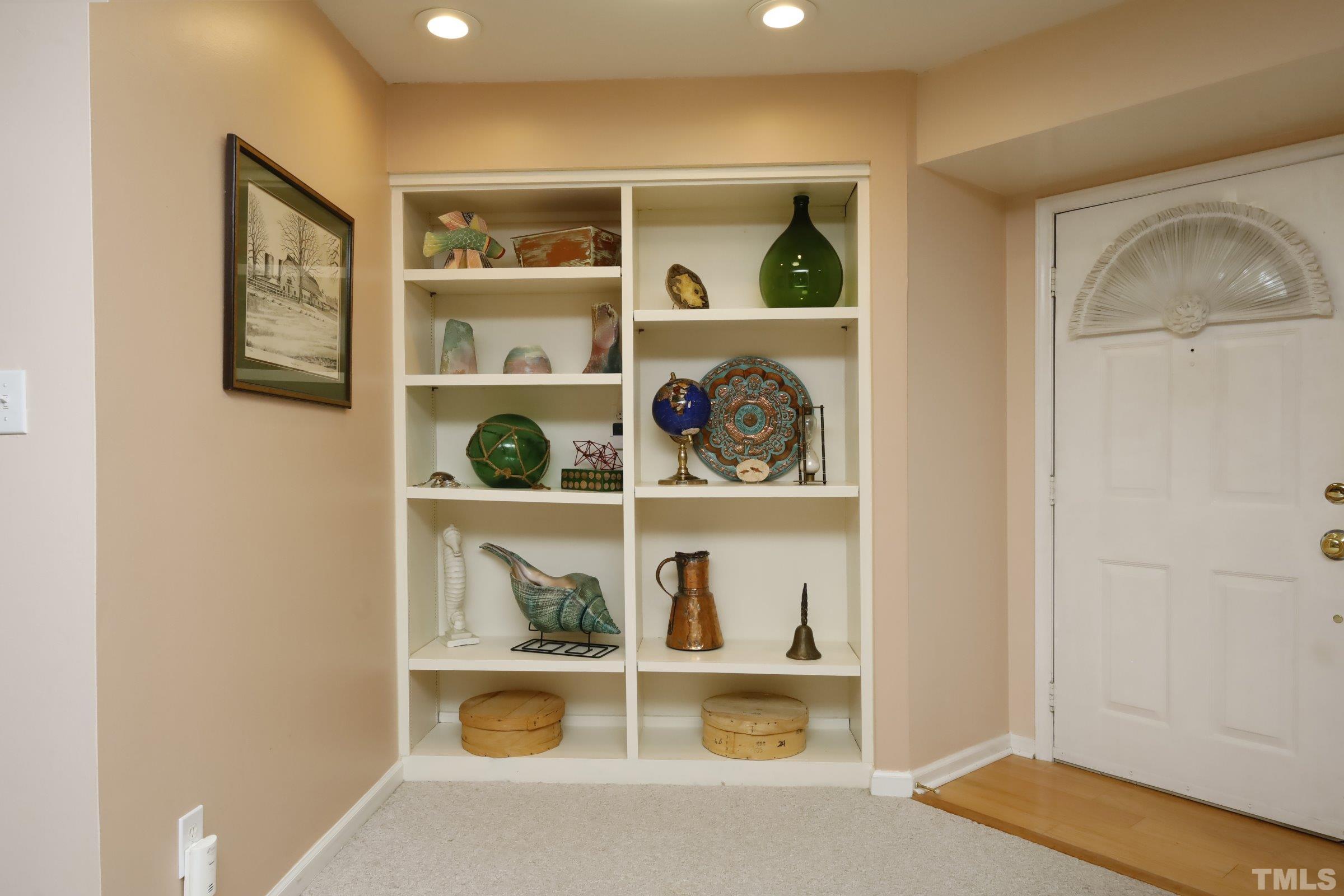 8331 Hempshire Place, Unit 102 Raleigh, NC 27613 - Photo 8 of 40 a shelf with books and knick knacks on it
