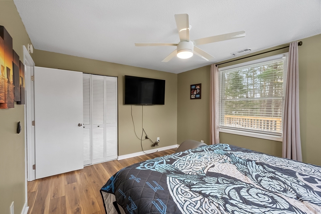 24 George Street Charlton, MA 01507 - Photo 24 of 42 a bedroom with a large bed and a flat tv screen