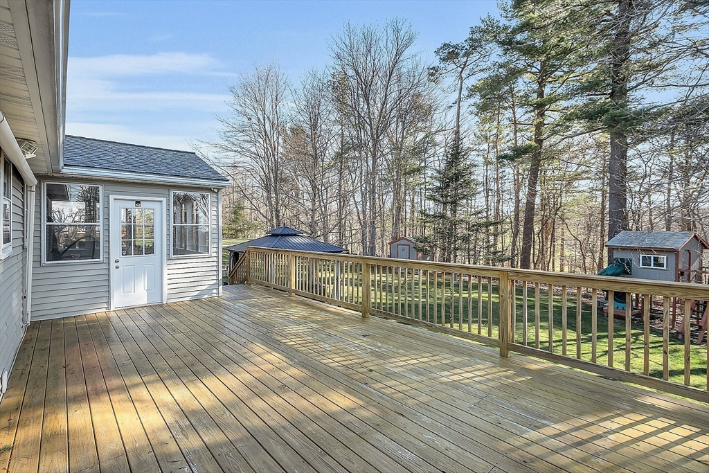24 George Street Charlton, MA 01507 - Photo 39 of 42 a view of house with deck outdoor seating and trees in the background