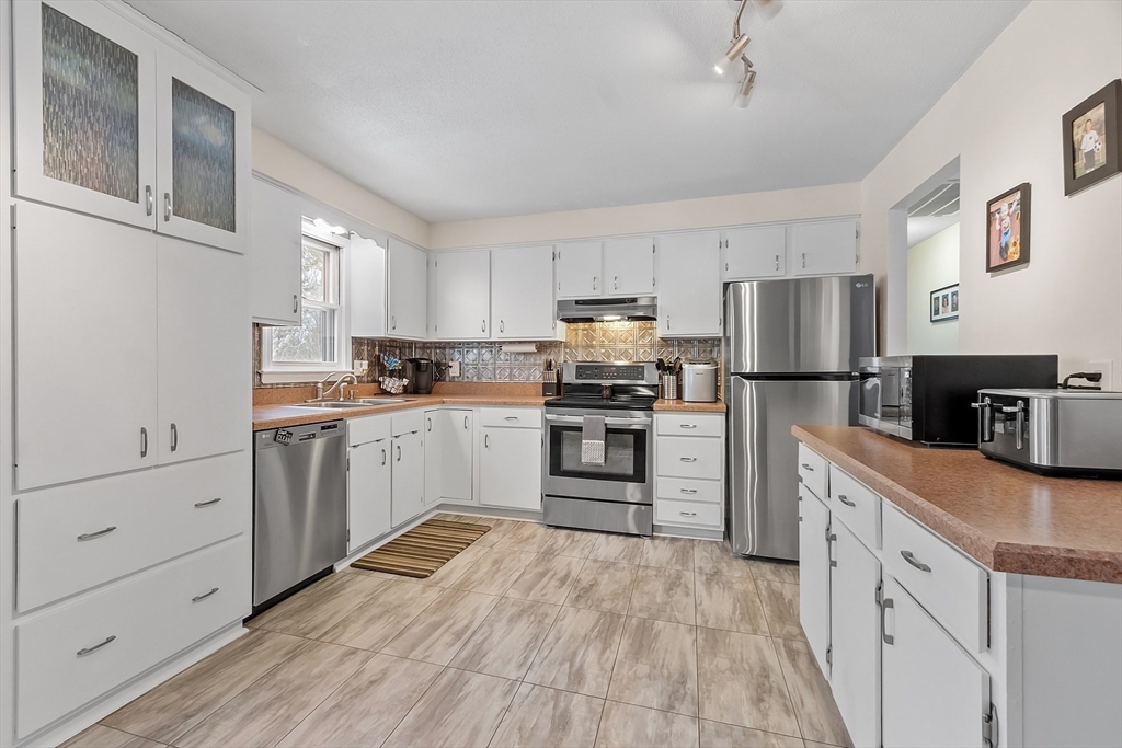 24 George Street Charlton, MA 01507 - Photo 8 of 42 a kitchen with white cabinets and stainless steel appliances