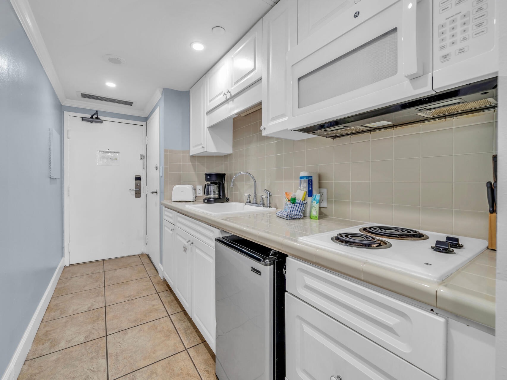 1096 Scenic Gulf Drive, Unit 1401/1401A Miramar Beach, FL 32550 - Photo 32 of 77 a kitchen with stainless steel appliances a sink a stove and cabinets