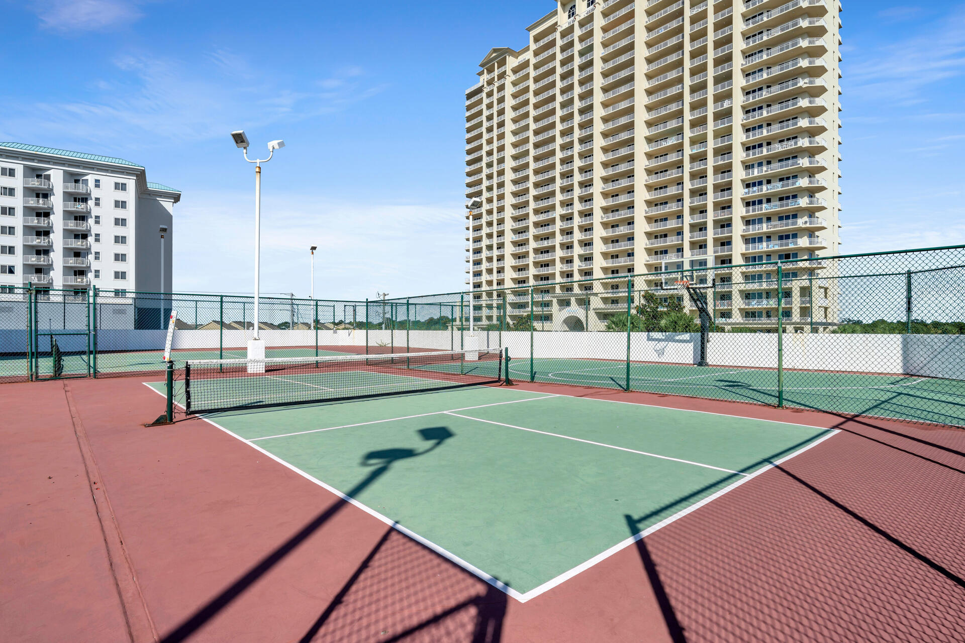 1096 Scenic Gulf Drive, Unit 1401/1401A Miramar Beach, FL 32550 - Photo 63 of 77 a view of a tennis ground with large trees
