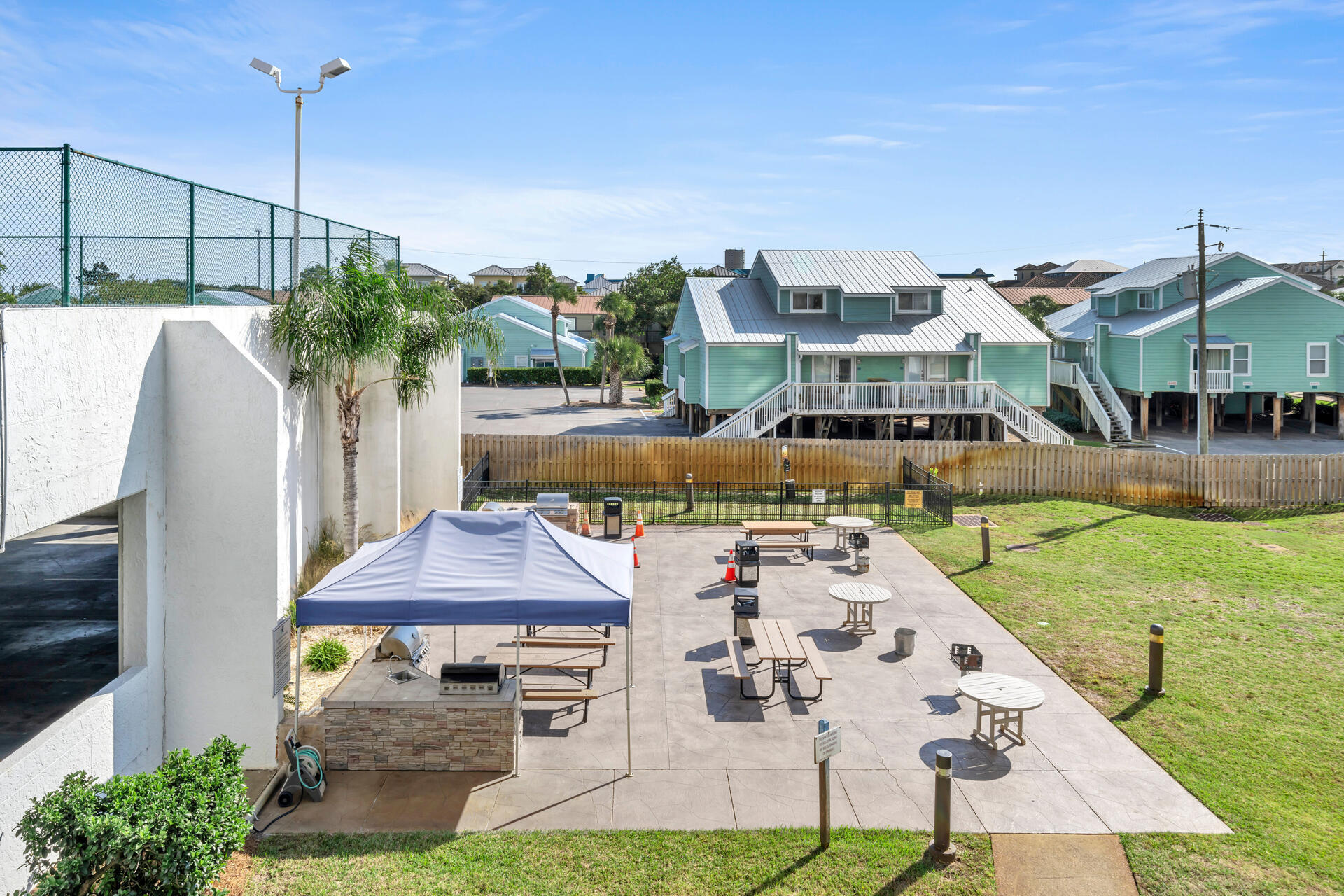 1096 Scenic Gulf Drive, Unit 1401/1401A Miramar Beach, FL 32550 - Photo 70 of 77 a view of a patio with table and chairs potted plants and a palm tree
