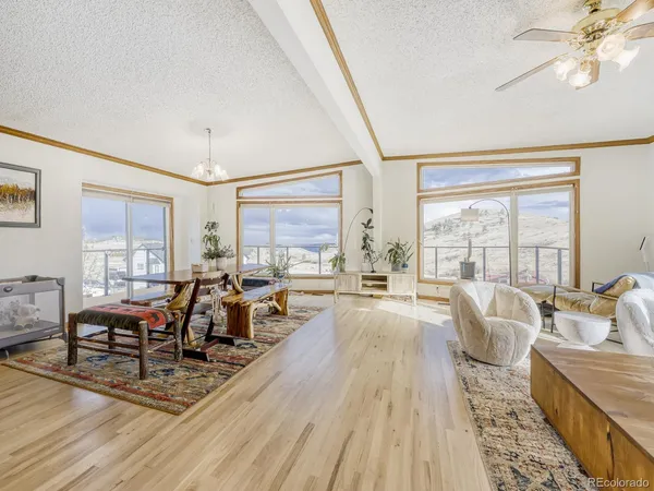 a living room with furniture large window and wooden floor