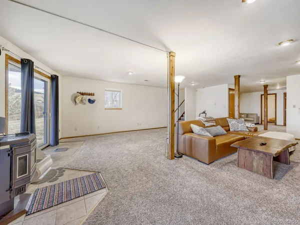 a living room with couches large window and flat screen tv
