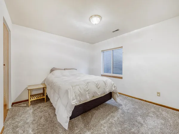 a spacious bedroom with a bed and a window