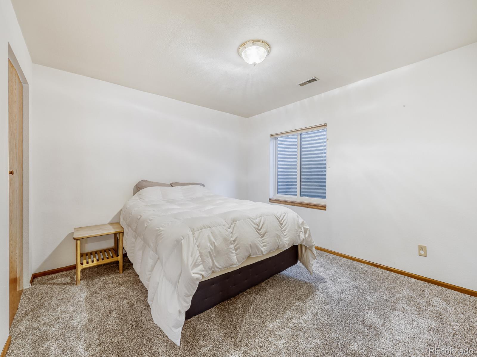 32020 Robinson Hill Road Golden, CO 80403 - Photo 25 of 28 a spacious bedroom with a bed and a window