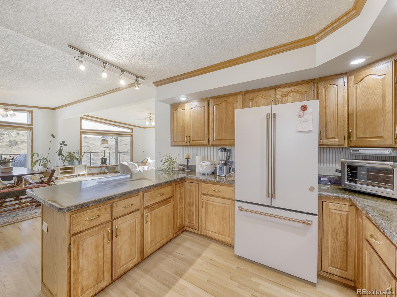 32020 Robinson Hill Road Golden, CO 80403 - Photo 9 of 28 a kitchen with a sink refrigerator and cabinets