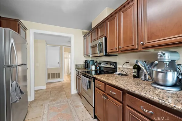 a kitchen with granite countertop a cabinets and refrigerator