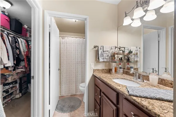 a bathroom with a granite countertop sink a mirror and a shower
