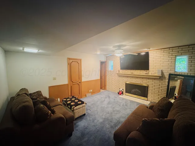 a living room with furniture a fireplace and a flat screen tv