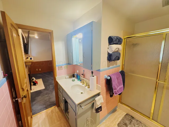a bathroom with a sink mirror and shower