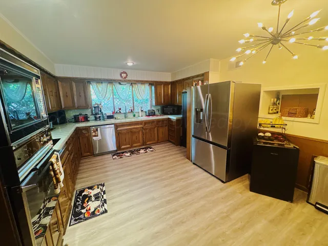 a kitchen with stainless steel appliances granite countertop a refrigerator stove and sink