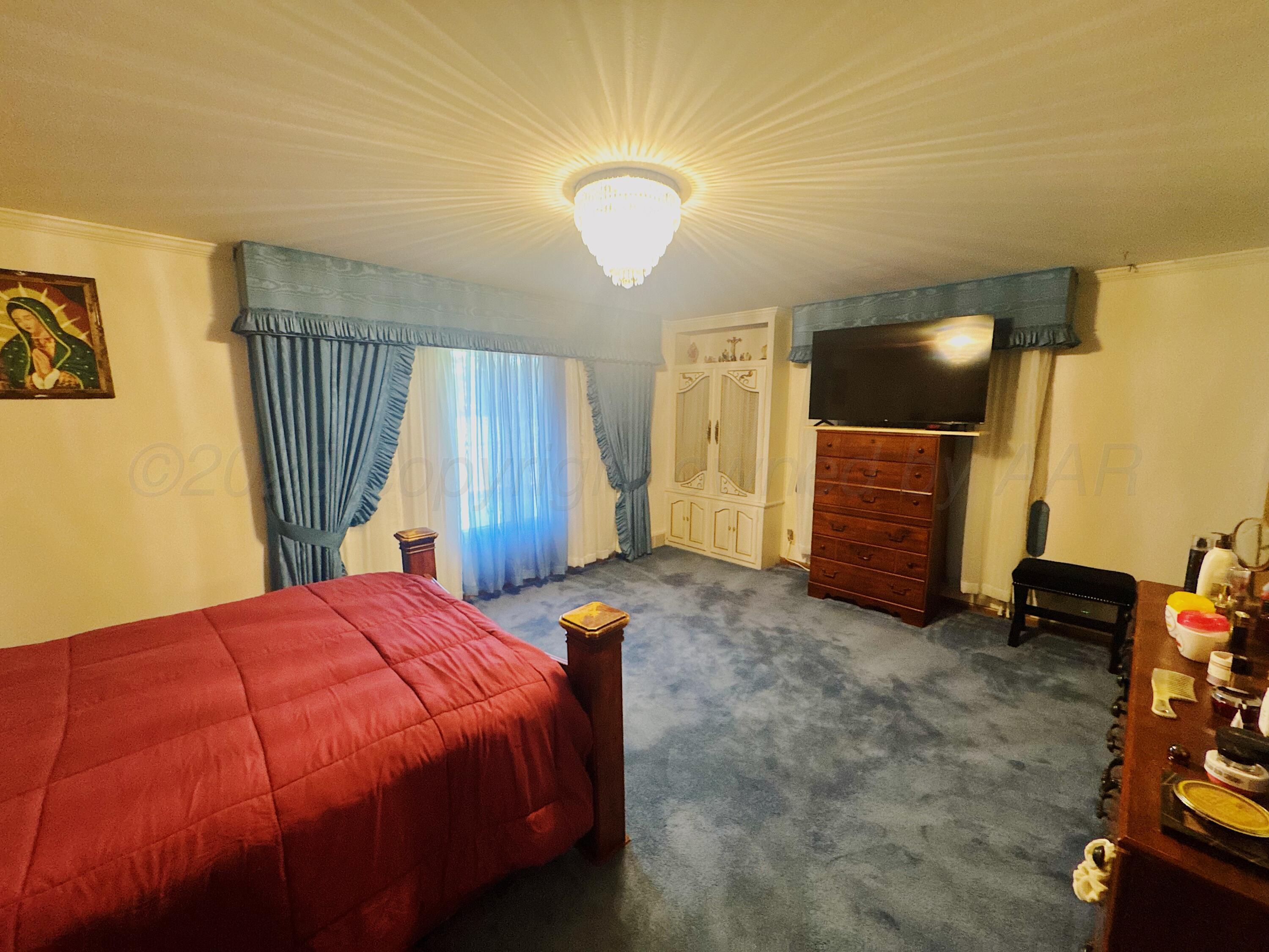 1421 South Fordham Street Perryton, TX 79070 - Photo 8 of 20 a bedroom with a bed and a chair