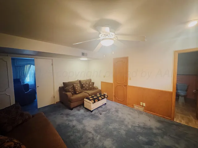 a living room with furniture and a ceiling fan