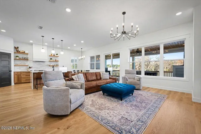 a living room with furniture a table and kitchen view
