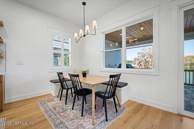 a kitchen with stainless steel appliances granite countertop a refrigerator a sink dishwasher a stove and white cabinets with wooden floor