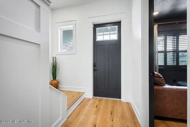a view of entryway and hall with wooden floor