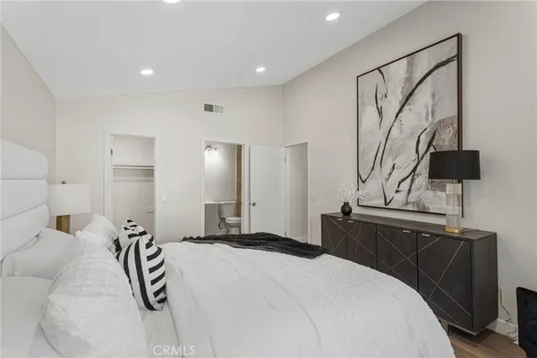 a bedroom with a bed and dresser with mirror