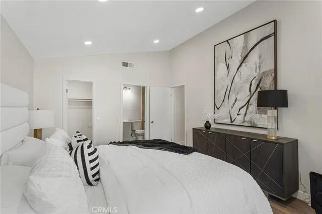 a bedroom with a bed and dresser with mirror