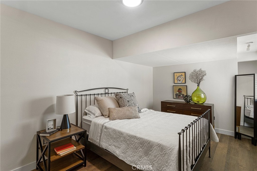 23020 Mansfield Lane Moreno Valley, CA 92557 - Photo 14 of 28 a bedroom with a bed and a dresser with wooden floor