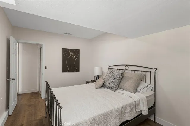 a bedroom with a bed and painting on the wall