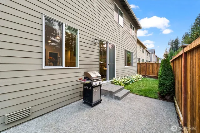 a view of a backyard with wooden fence and plants