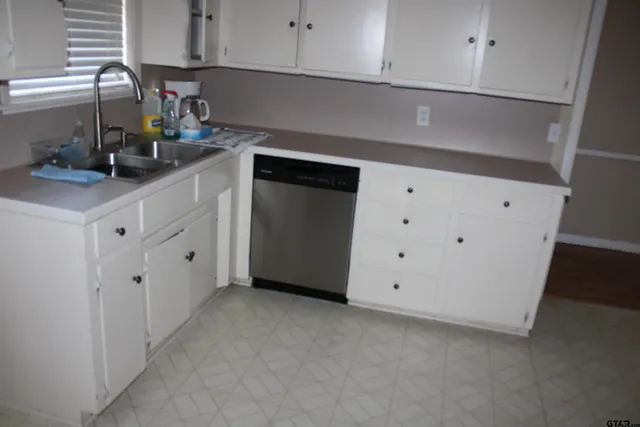 a kitchen with stainless steel appliances white cabinets and a sink