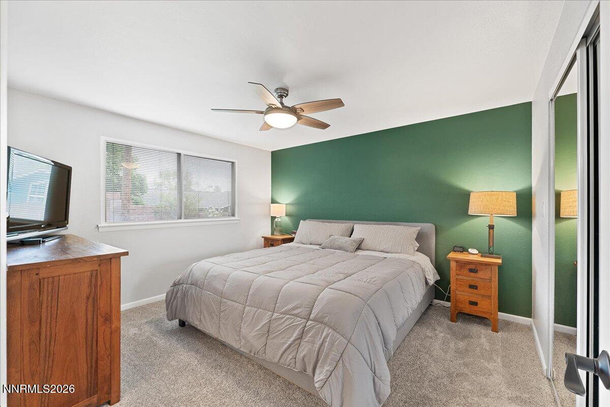 2205 Carlin Street Reno, NV 89503 - Photo 18 of 51 a bedroom with a bed a window and a flat screen tv