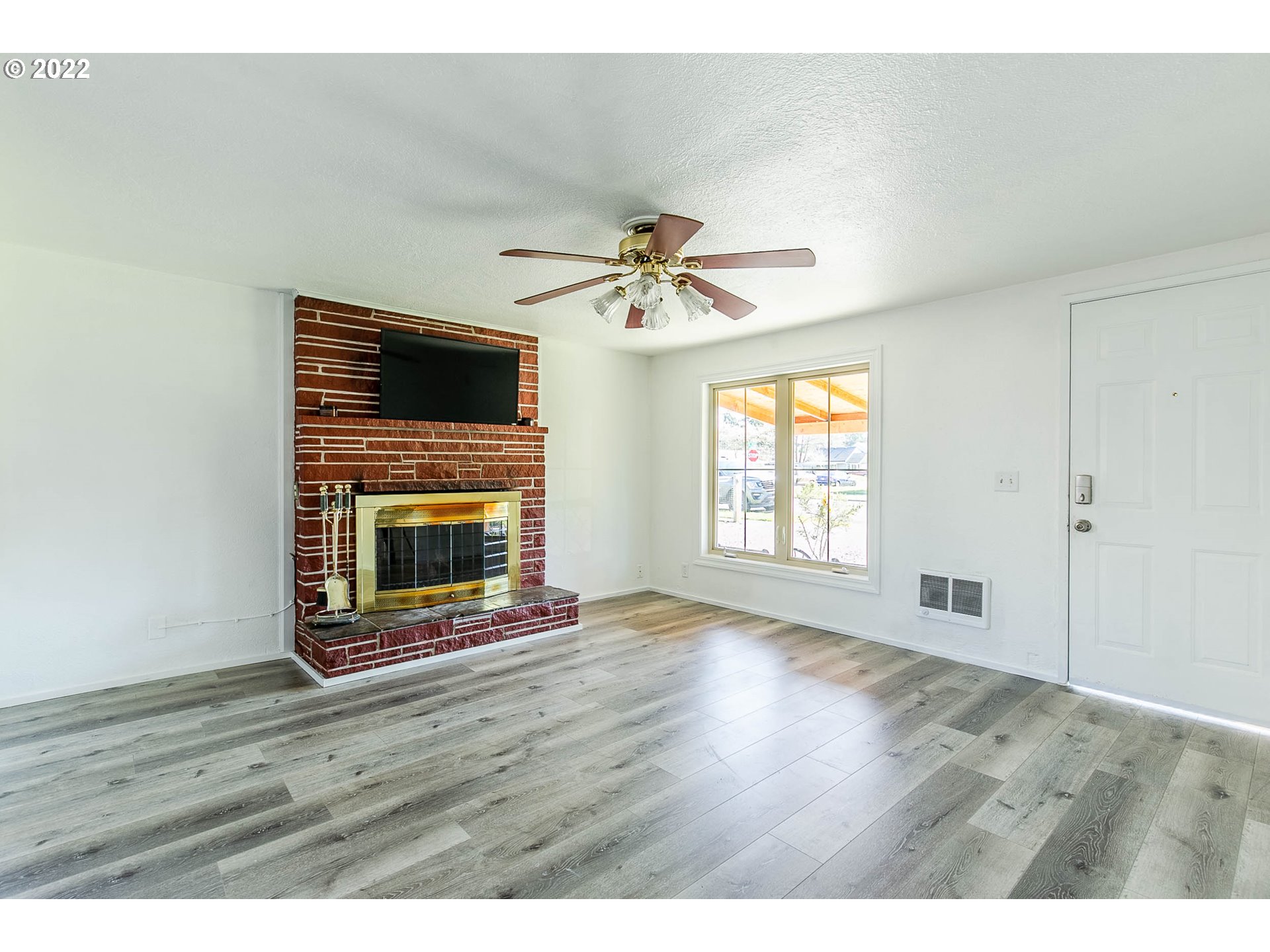 1158 D Street Springfield, OR 97477 - Photo 4 of 24 a view of an empty room with a fireplace and a window