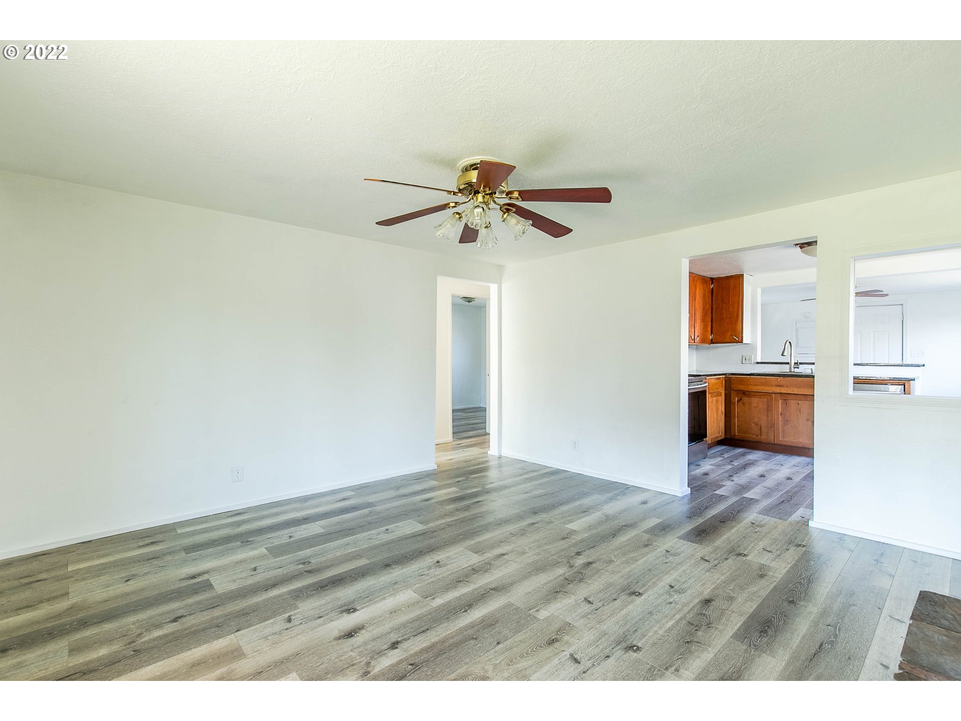 1158 D Street Springfield, OR 97477 - Photo 6 of 24 a view of a kitchen with wooden floor and a ceiling fan