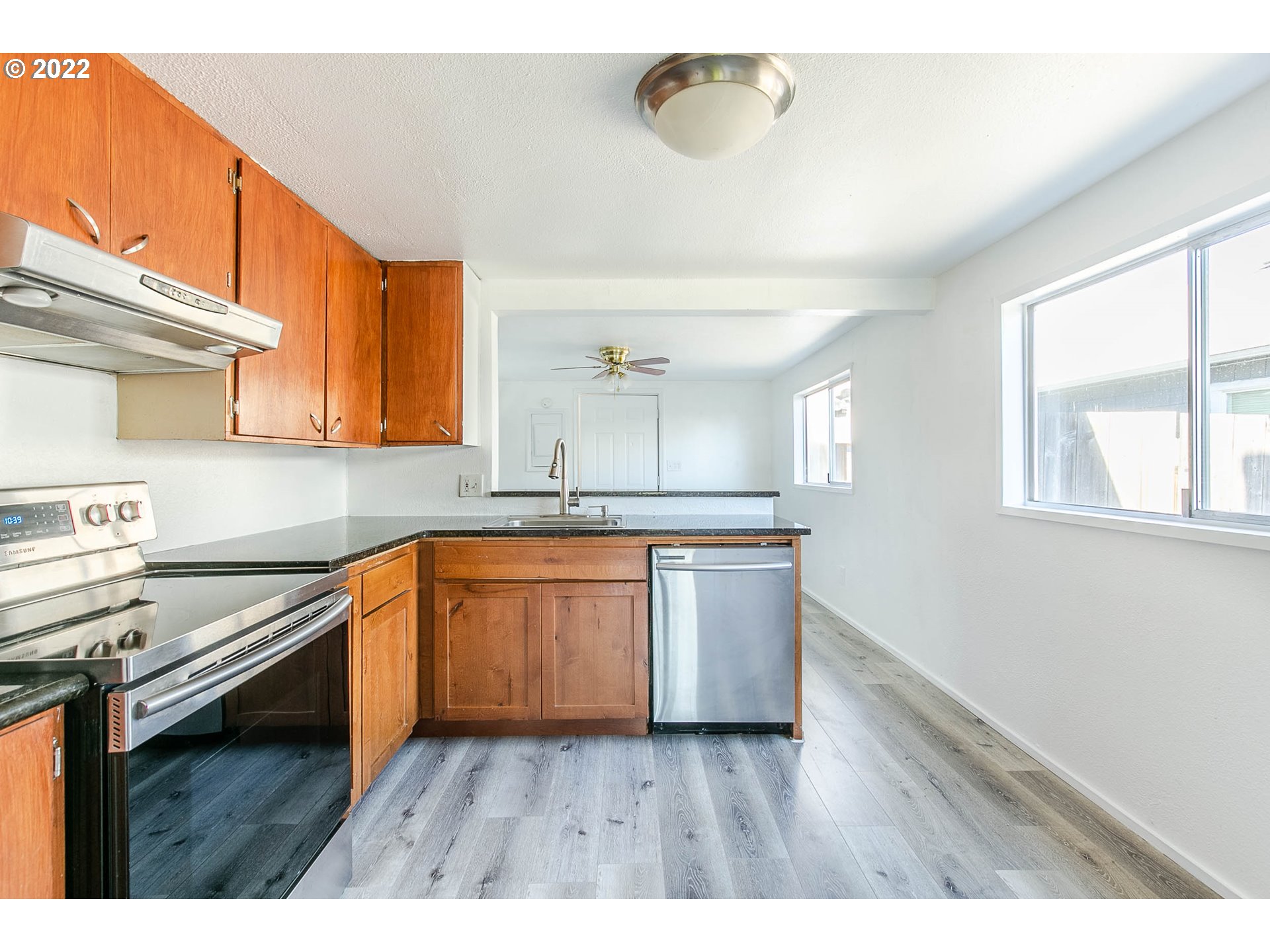 1158 D Street Springfield, OR 97477 - Photo 7 of 24 a kitchen with granite countertop a stove a sink and a microwave
