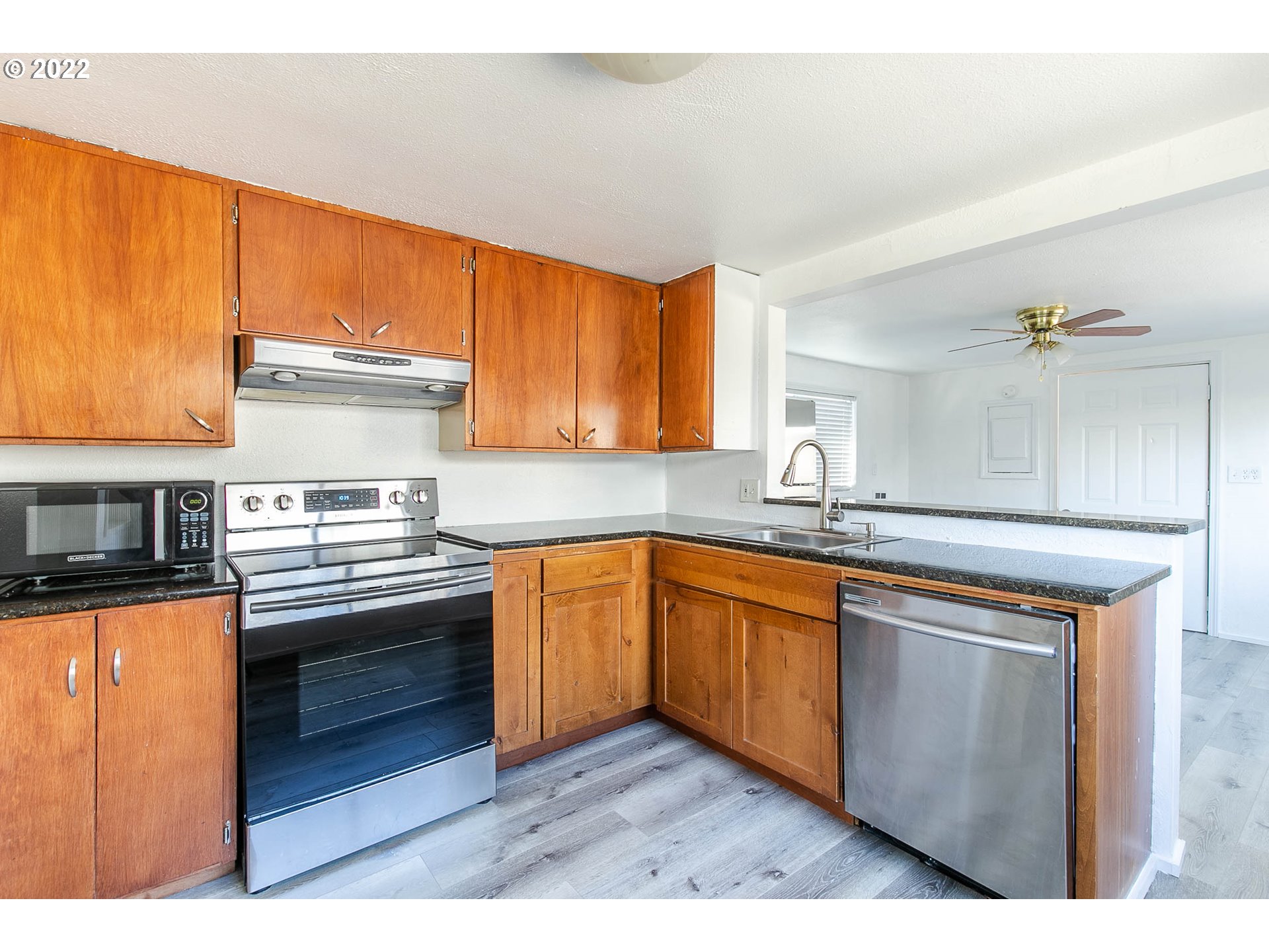 1158 D Street Springfield, OR 97477 - Photo 8 of 24 a kitchen with stainless steel appliances granite countertop wooden cabinets a stove and a sink