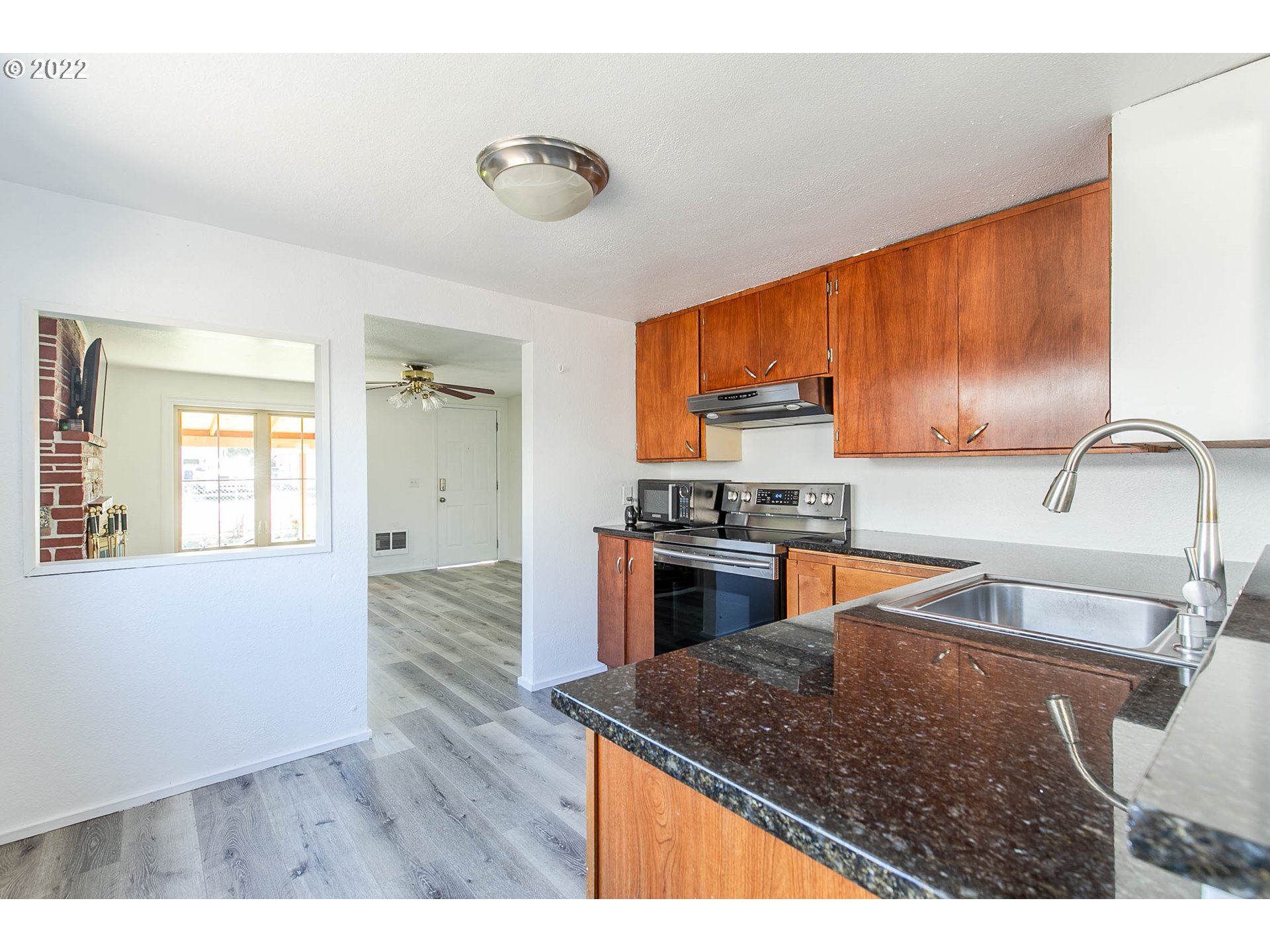 1158 D Street Springfield, OR 97477 - Photo 9 of 24 a kitchen with stainless steel appliances granite countertop a sink a stove and a wooden cabinets