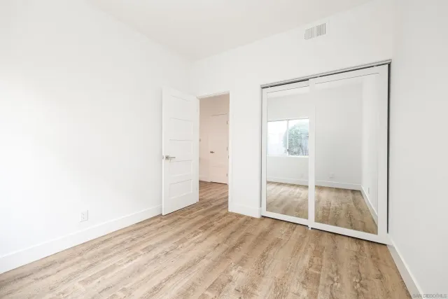 an empty room with wooden floor and door
