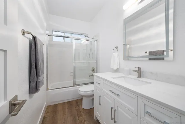 a bathroom with a granite countertop sink toilet and shower