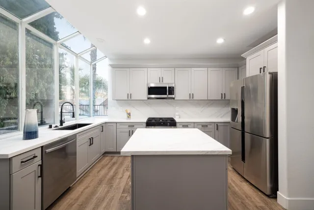 a kitchen with a sink a refrigerator and a stove top oven